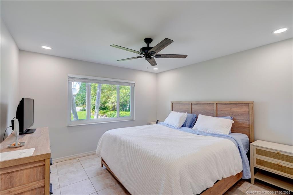 5539 Northeast Gulfstream Way Stuart, FL 34996 - Photo 24 of 26 a bedroom with a bed and a window