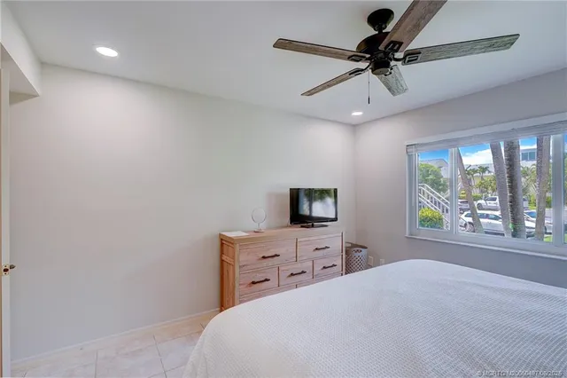 a bedroom with a bed and a ceiling fan