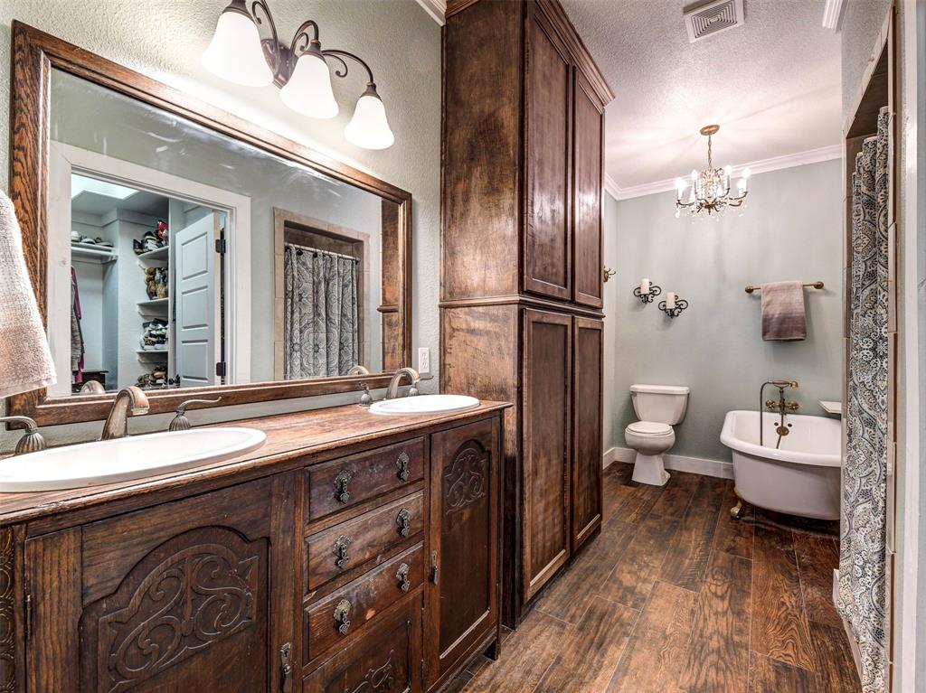 4983 Applegate Road Bowie, TX 76230 - Photo 20 of 40 a spacious bathroom with a double vanity sink mirror and toilet