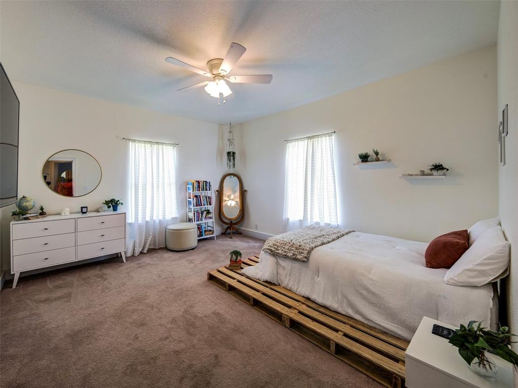 4983 Applegate Road Bowie, TX 76230 - Photo 24 of 40 a bedroom with a bed and a chandelier