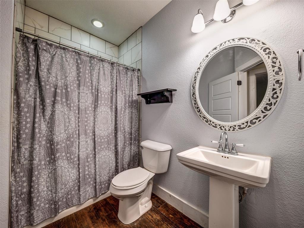 4983 Applegate Road Bowie, TX 76230 - Photo 25 of 40 a bathroom with a sink a toilet and shower curtain