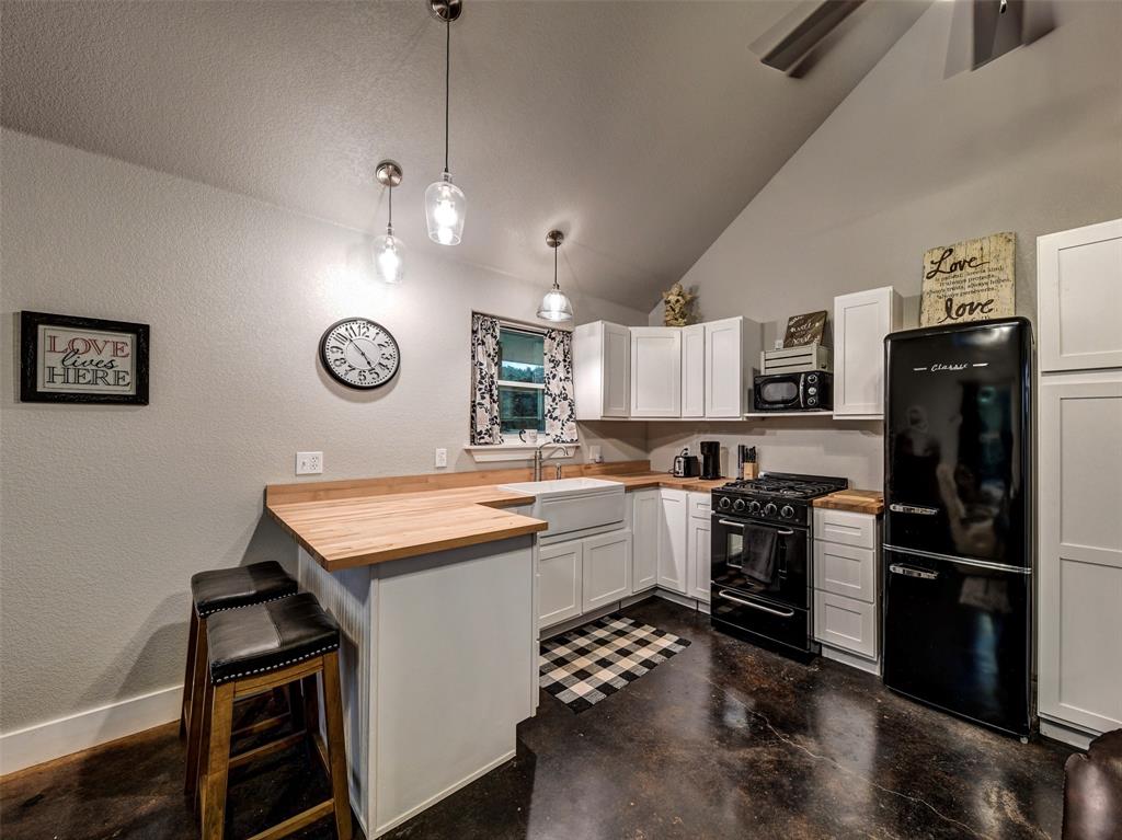 4983 Applegate Road Bowie, TX 76230 - Photo 32 of 40 a kitchen with a refrigerator a microwave and stove