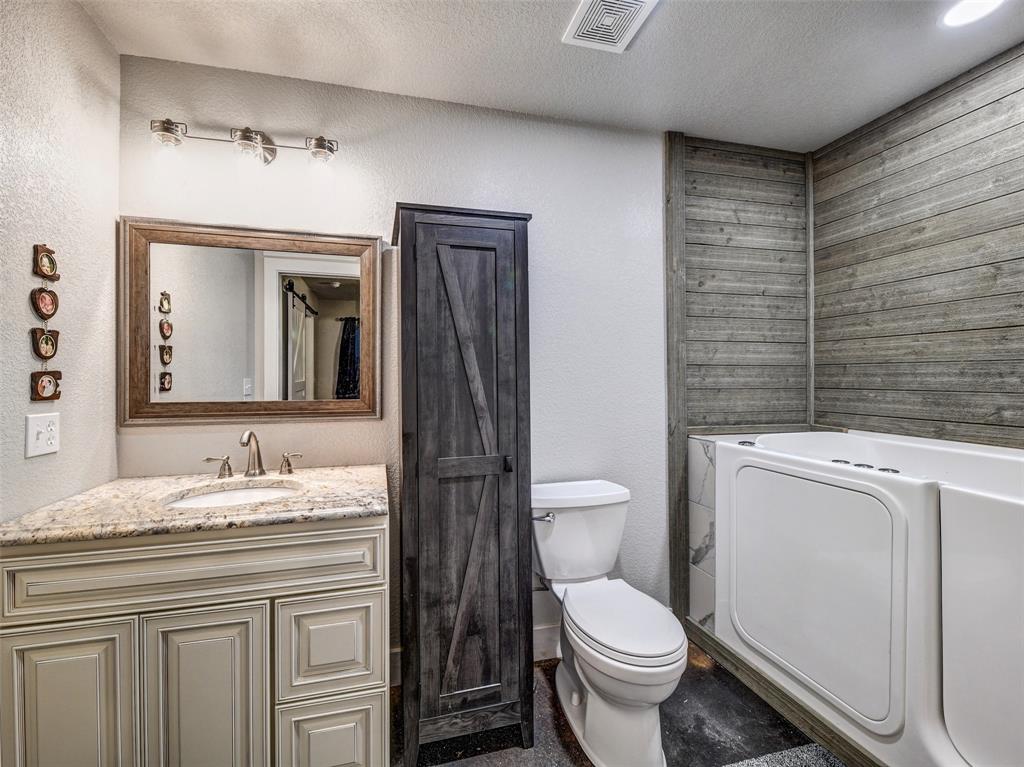 4983 Applegate Road Bowie, TX 76230 - Photo 35 of 40 a bathroom with a granite countertop toilet sink and mirror