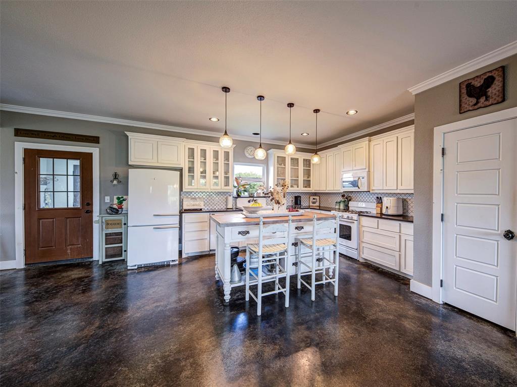 4983 Applegate Road Bowie, TX 76230 - Photo 10 of 40 a kitchen with stainless steel appliances a dining table chairs and view living room