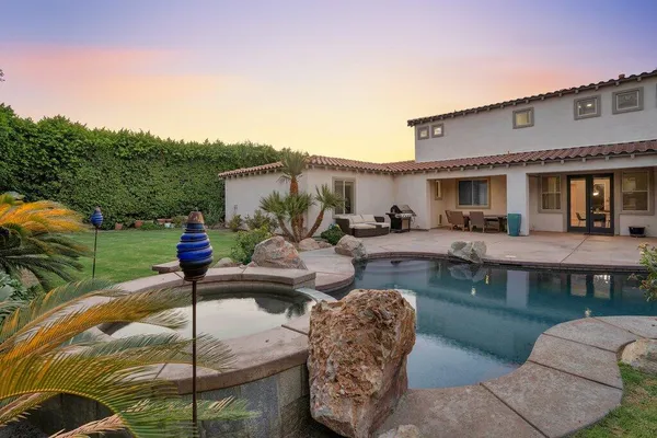 a view of a backyard with table and chairs and potted plants