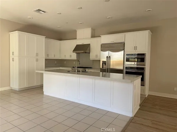 a kitchen with stainless steel appliances granite countertop a refrigerator and a stove