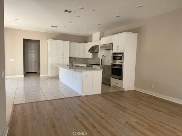 a kitchen with stainless steel appliances granite countertop a stove top oven a sink and a refrigerator