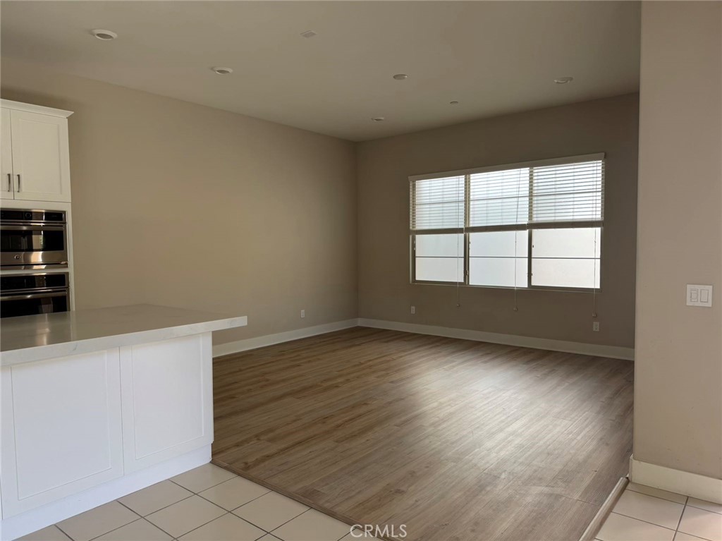 171 Interval Irvine, CA 92618 - Photo 6 of 19 an empty room with wooden floor and windows