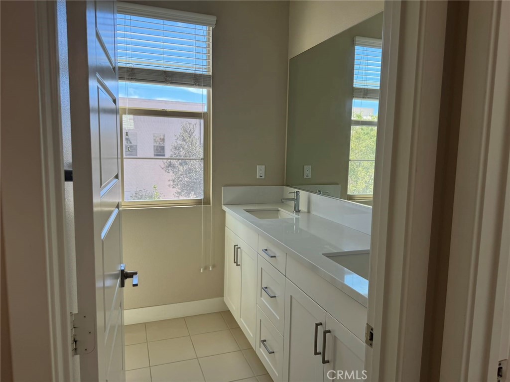 171 Interval Irvine, CA 92618 - Photo 7 of 19 a bathroom with a granite countertop sink and a mirror