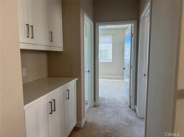 a view of a hallway with an empty room and window