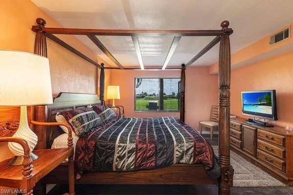 a bedroom with a bed and a window