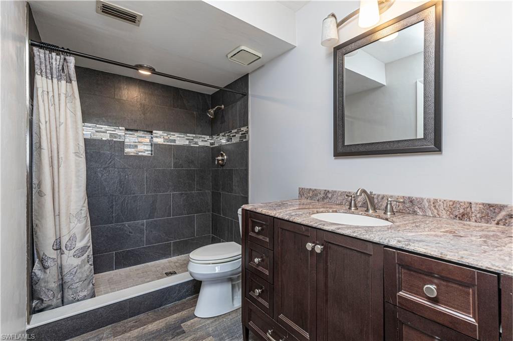 3832 Snowflake Lane, Unit 1207 Naples, FL 34112 - Photo 14 of 22 a bathroom with a granite countertop sink a mirror and a shower