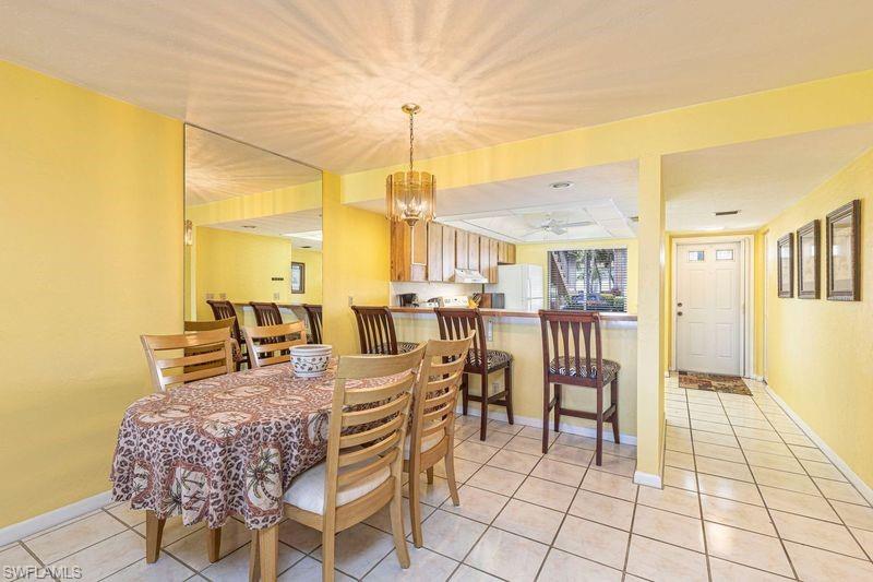 3832 Snowflake Lane, Unit 1207 Naples, FL 34112 - Photo 4 of 22 a dining room with furniture and floor to ceiling window