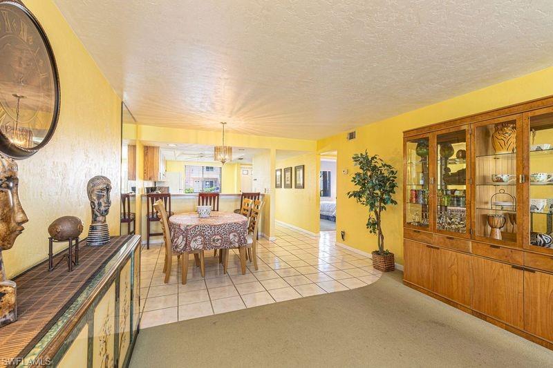 3832 Snowflake Lane, Unit 1207 Naples, FL 34112 - Photo 7 of 22 a dining room with furniture and a floor to ceiling window