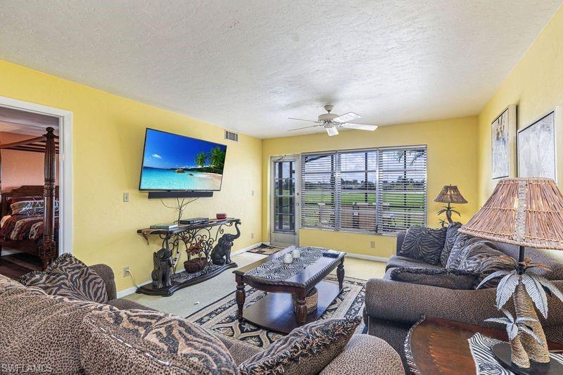 3832 Snowflake Lane, Unit 1207 Naples, FL 34112 - Photo 8 of 22 a living room with furniture and a flat screen tv