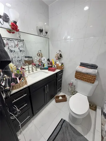 a bathroom with a sink vanity mirror and toilet