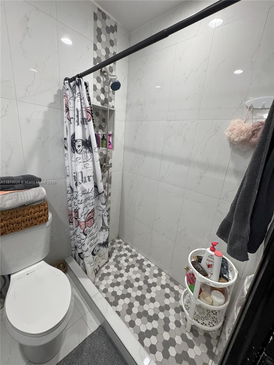 6411 West 27th Way, Unit 201 Hialeah, FL 33016 - Photo 12 of 21 a bathroom with a toilet sink and shower curtain