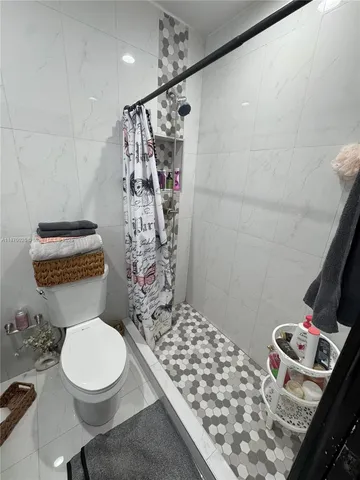 a bathroom with a toilet and shower curtain