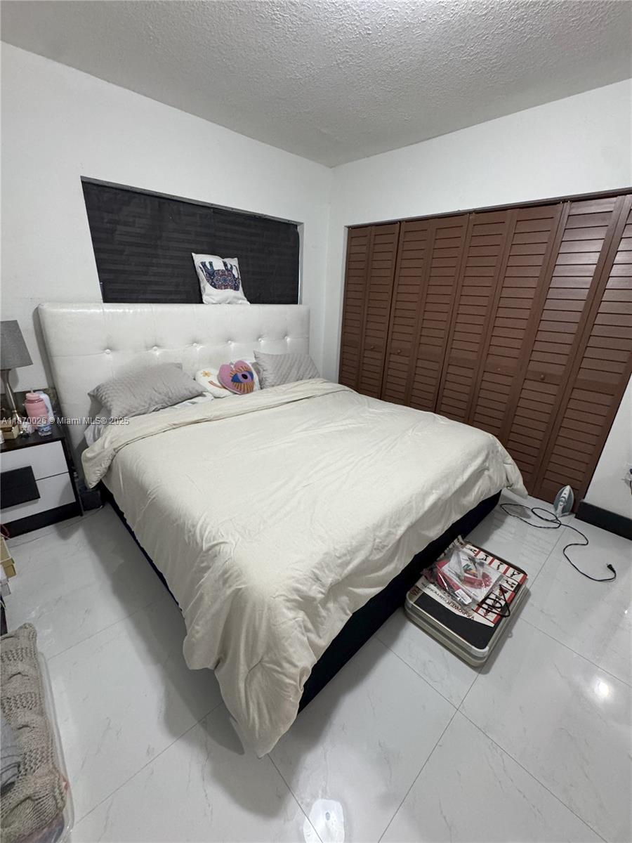 6411 West 27th Way, Unit 201 Hialeah, FL 33016 - Photo 14 of 21 a large bed sitting in a bedroom and wooden floor