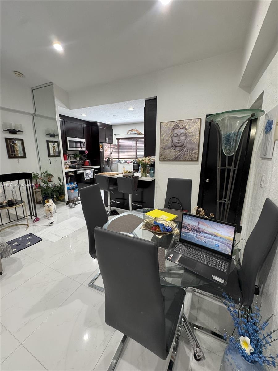 6411 West 27th Way, Unit 201 Hialeah, FL 33016 - Photo 15 of 21 a living room with furniture a flat screen tv and a fireplace