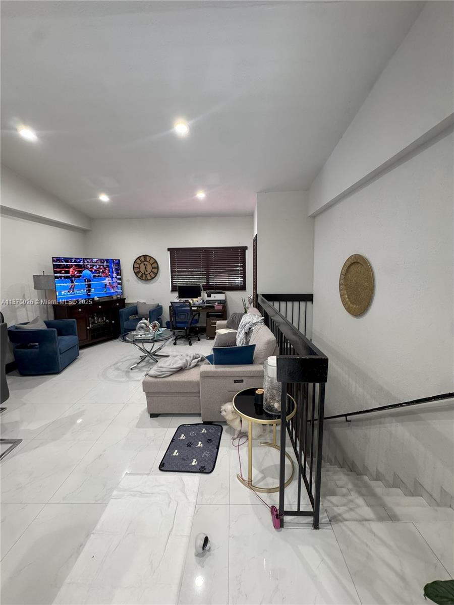 6411 West 27th Way, Unit 201 Hialeah, FL 33016 - Photo 7 of 21 a living room with furniture and a gym equipment