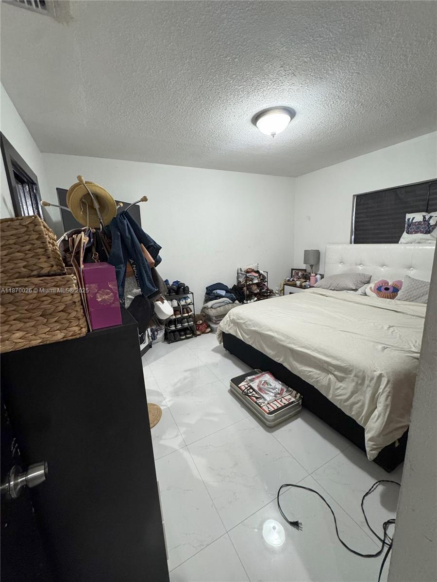 6411 West 27th Way, Unit 201 Hialeah, FL 33016 - Photo 8 of 21 a bedroom with a bed and a closet