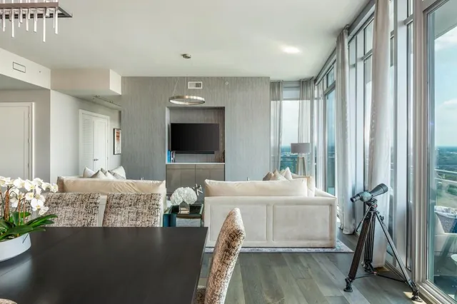 a view of a dining room with furniture one side kitchen view and wooden floor