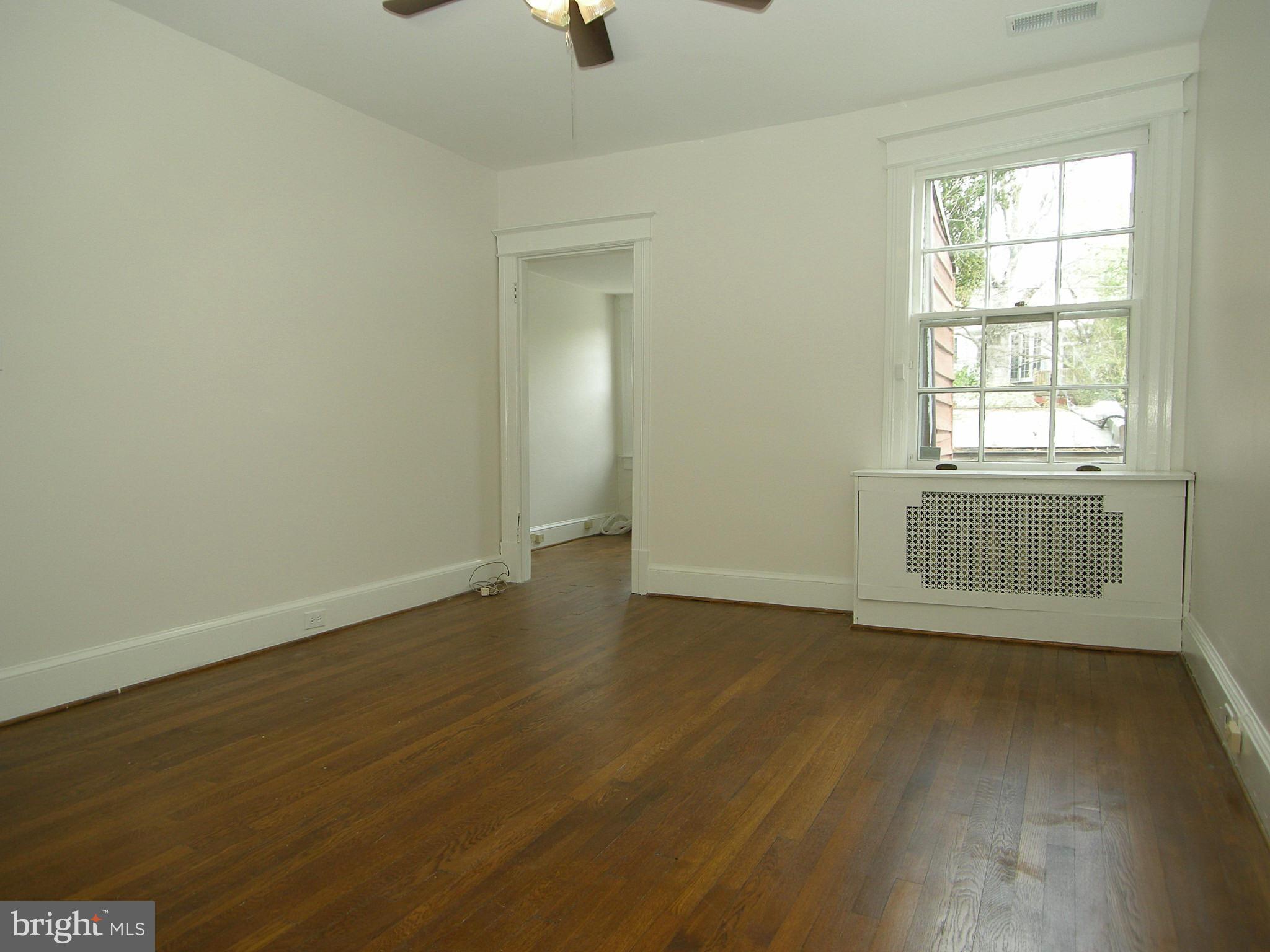 2815 Woodley Road Northwest Washington, DC 20008 - Photo 16 of 25 an empty room with wooden floor cabinet and windows