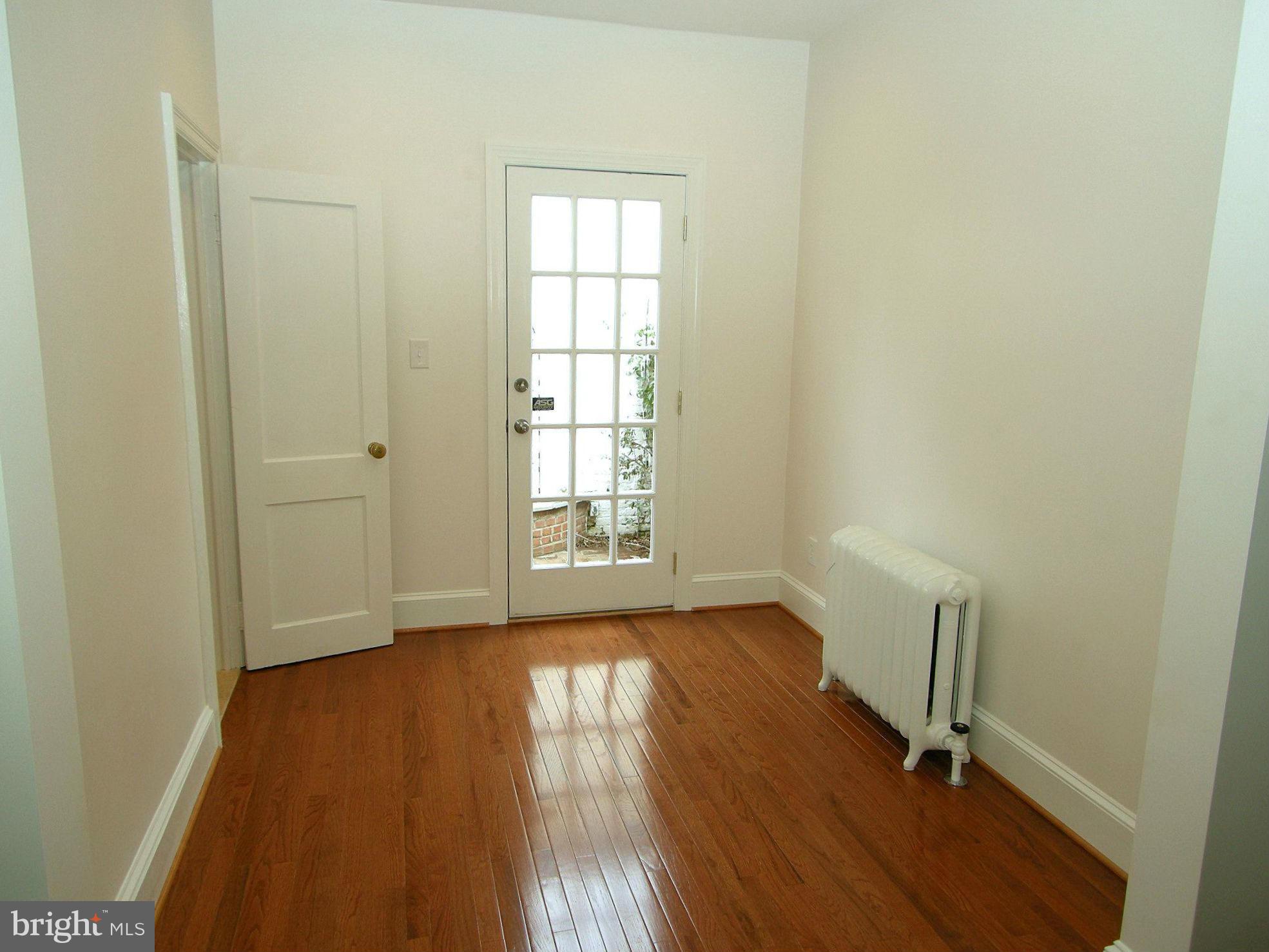 2815 Woodley Road Northwest Washington, DC 20008 - Photo 8 of 25 an empty room with wooden floor and windows