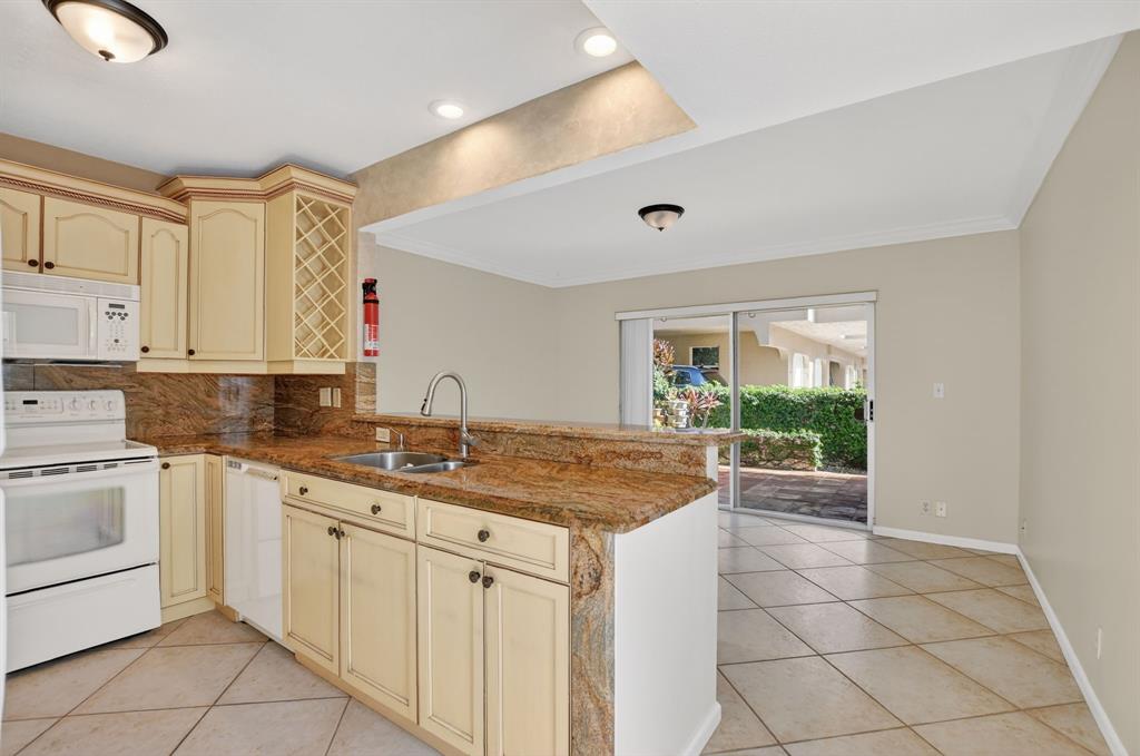 596 Southeast 20th Avenue, Unit 4 Deerfield Beach, FL 33441 - Photo 16 of 51 a kitchen with a sink and cabinets