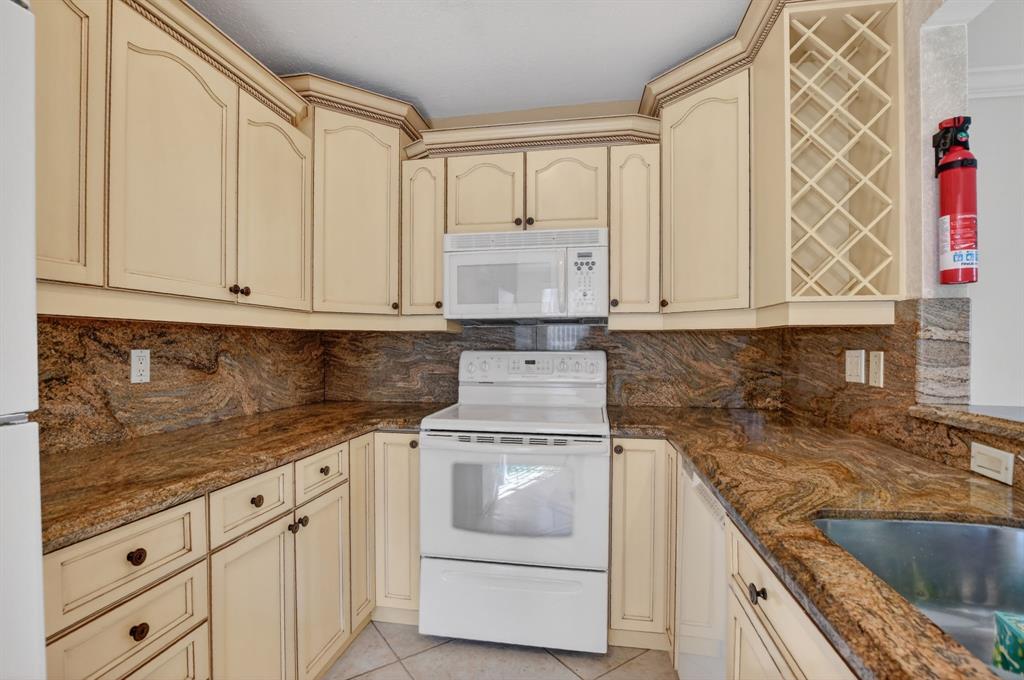 596 Southeast 20th Avenue, Unit 4 Deerfield Beach, FL 33441 - Photo 21 of 51 a kitchen with granite countertop white cabinets and stainless steel appliances