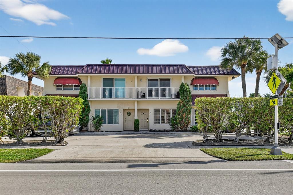 596 Southeast 20th Avenue, Unit 4 Deerfield Beach, FL 33441 - Photo 4 of 51 a front view of a building with garden