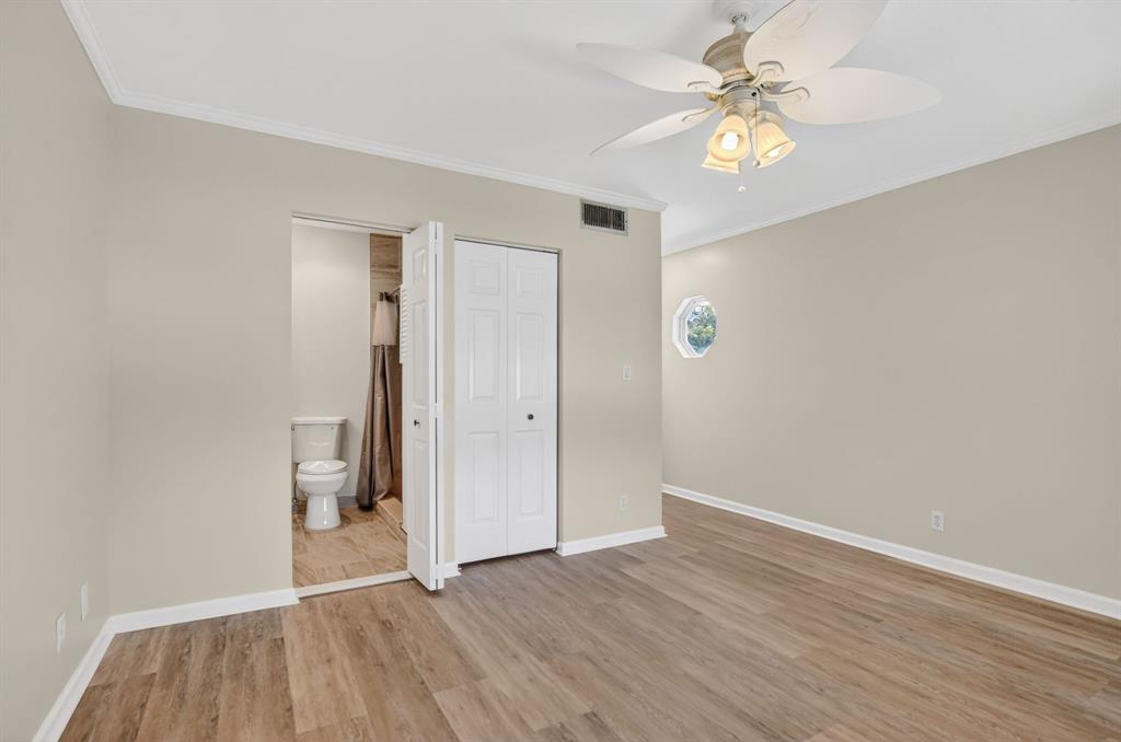 596 Southeast 20th Avenue, Unit 4 Deerfield Beach, FL 33441 - Photo 41 of 51 an empty room with wooden floor and a ceiling fan