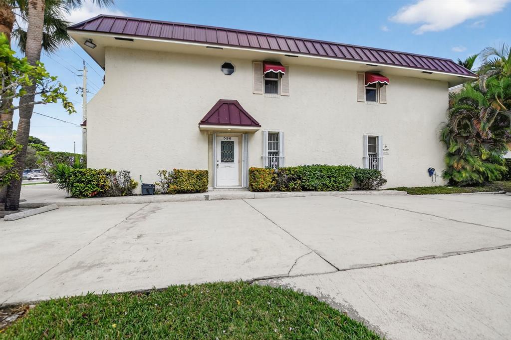 596 Southeast 20th Avenue, Unit 4 Deerfield Beach, FL 33441 - Photo 7 of 51 a front view of a house with a yard