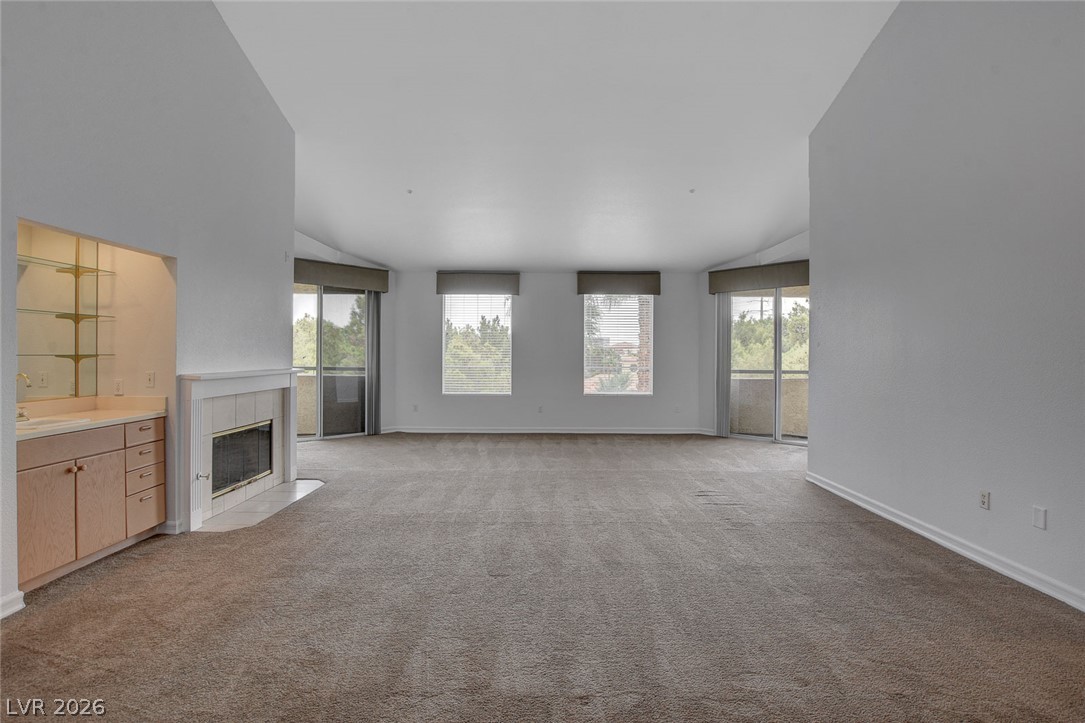 230 East Flamingo Road, Unit 404 Las Vegas, NV 89169 - Photo 7 of 34 High ceilings and a cozy fireplace anchor this open living area with sliding door access.