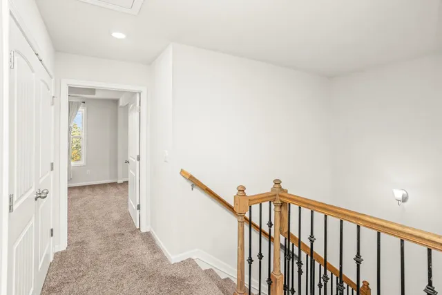 a view of a hallway with wooden floor and staircase