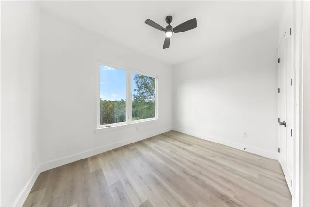 a view of a hallway with wooden floor and stairs
