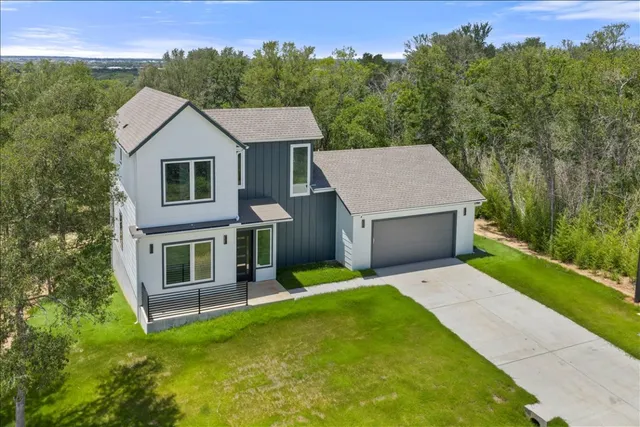 a aerial view of a house with a yard and trees