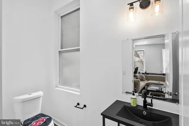 a bathroom with a sink a toilet and a mirror