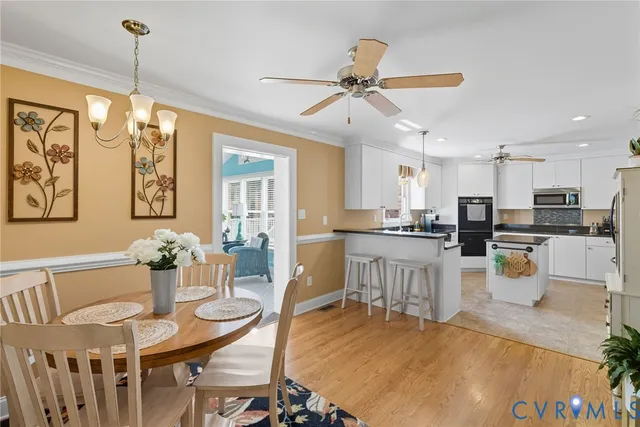 a view of a dining room and livingroom with furniture wooden floor a chandelier