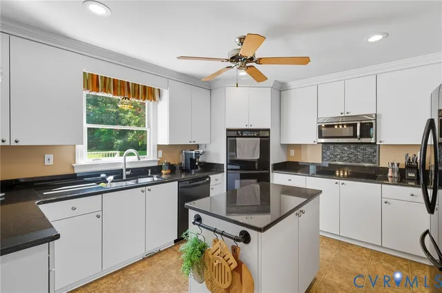 a kitchen with a stove a sink a microwave a refrigerator and cabinets