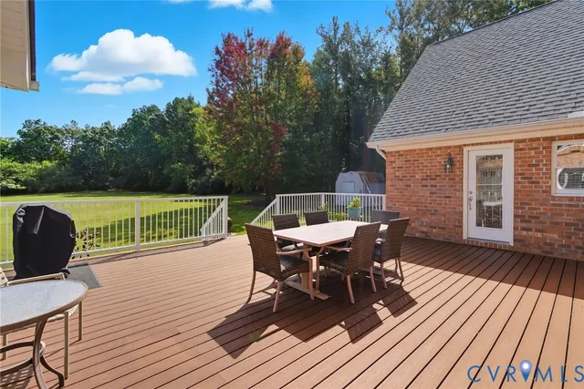 a view of a roof deck with table and chairs with wooden floor and fence