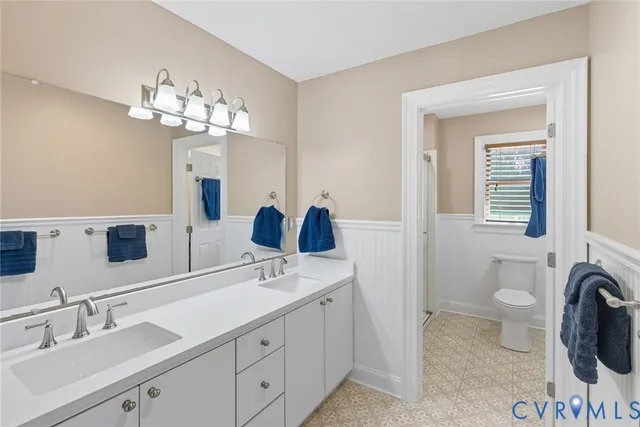 a bathroom with a sink a toilet and a mirror