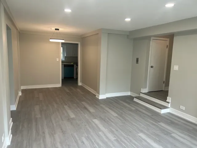 a view of an empty room with wooden floor and closet