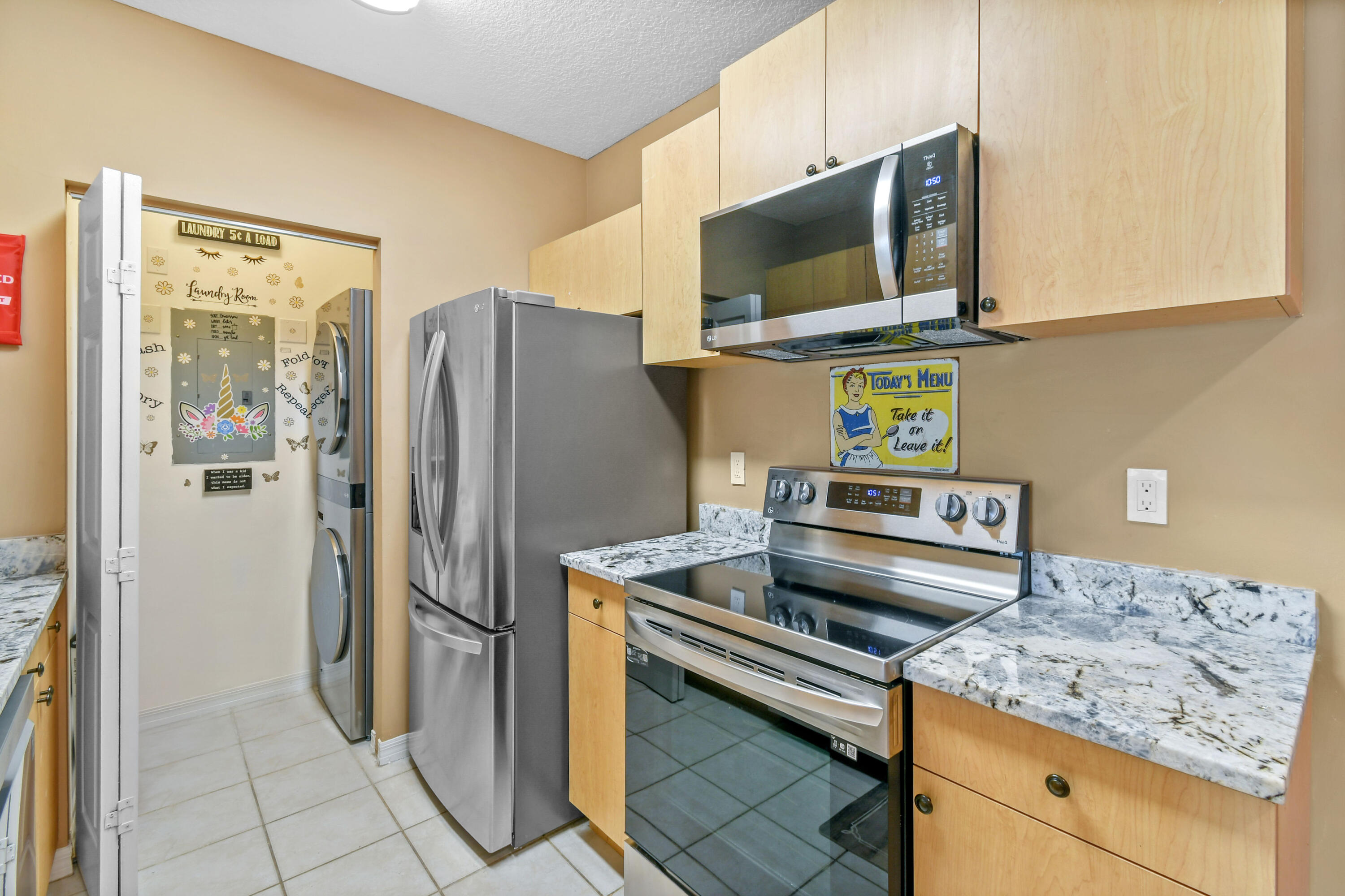 10354 Fox Trail Road South, Unit 1505 West Palm Beach, FL 33411 - Photo 15 of 76 a kitchen with stainless steel appliances granite countertop a refrigerator and a stove top oven