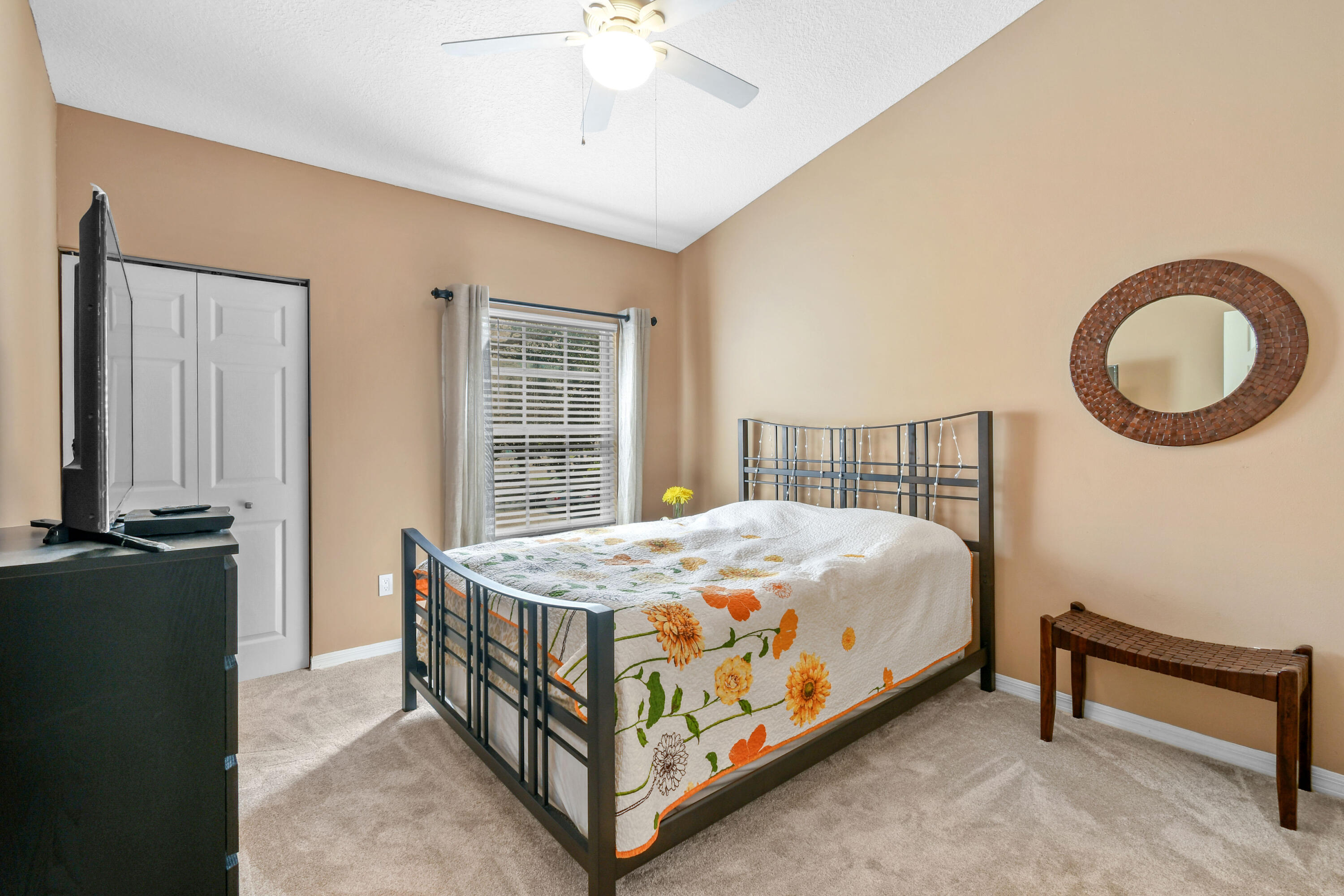 10354 Fox Trail Road South, Unit 1505 West Palm Beach, FL 33411 - Photo 17 of 76 a bedroom with a bed and a chandelier