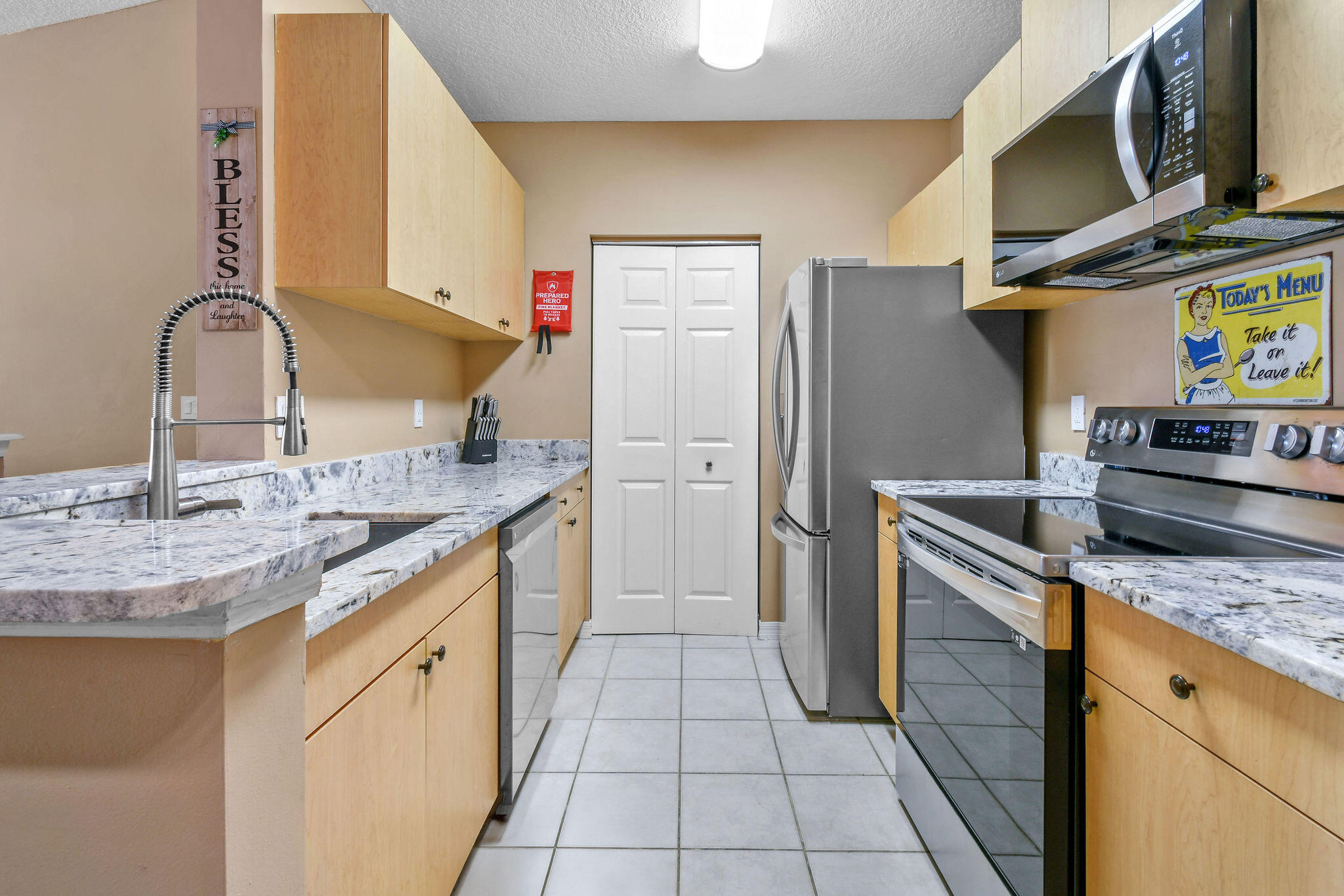 10354 Fox Trail Road South, Unit 1505 West Palm Beach, FL 33411 - Photo 55 of 76 a kitchen with stainless steel appliances granite countertop a sink and a stove