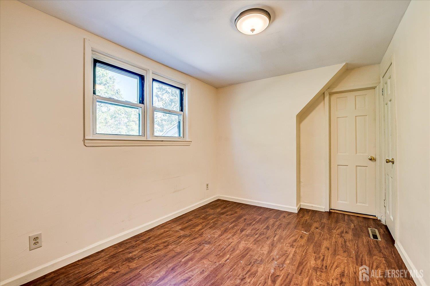 39 Rayle Court Metuchen, NJ 08840 - Photo 23 of 29 an empty room with wooden floor and windows