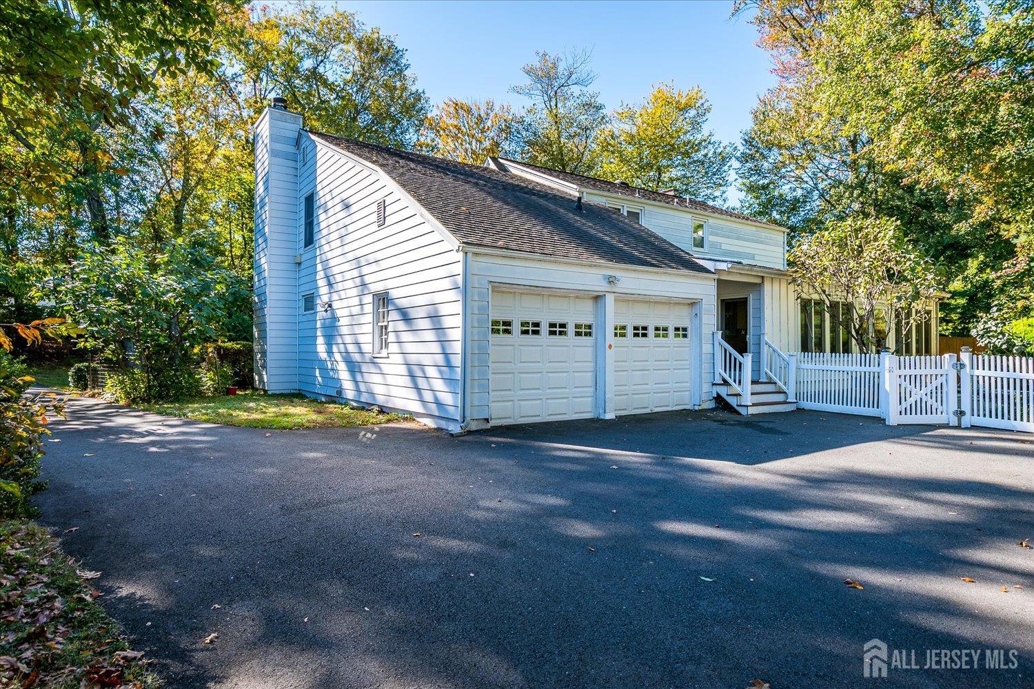 39 Rayle Court Metuchen, NJ 08840 - Photo 27 of 29 a view of a white house with a large parking space and trees