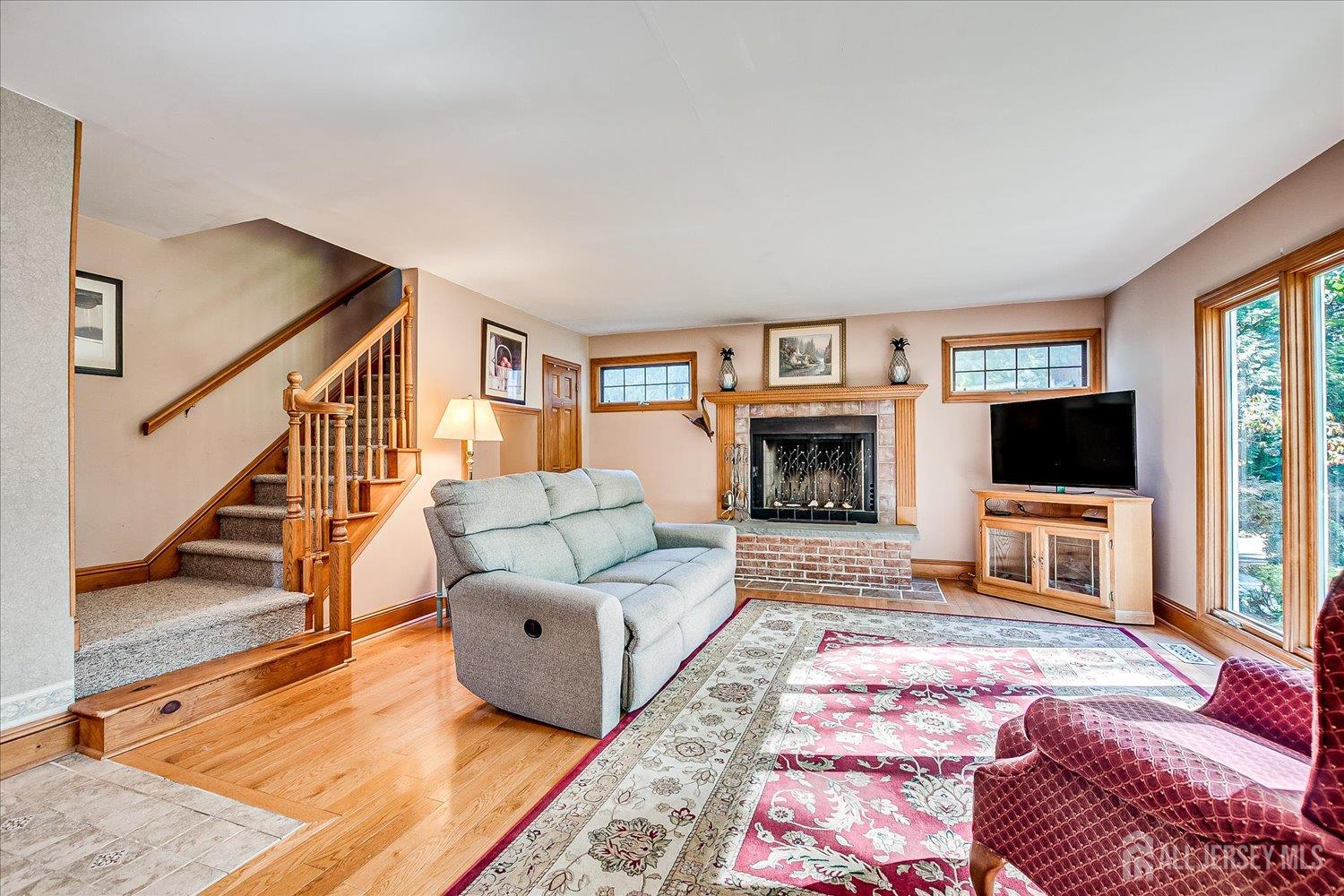 39 Rayle Court Metuchen, NJ 08840 - Photo 10 of 29 a living room with furniture flat screen tv and a fireplace